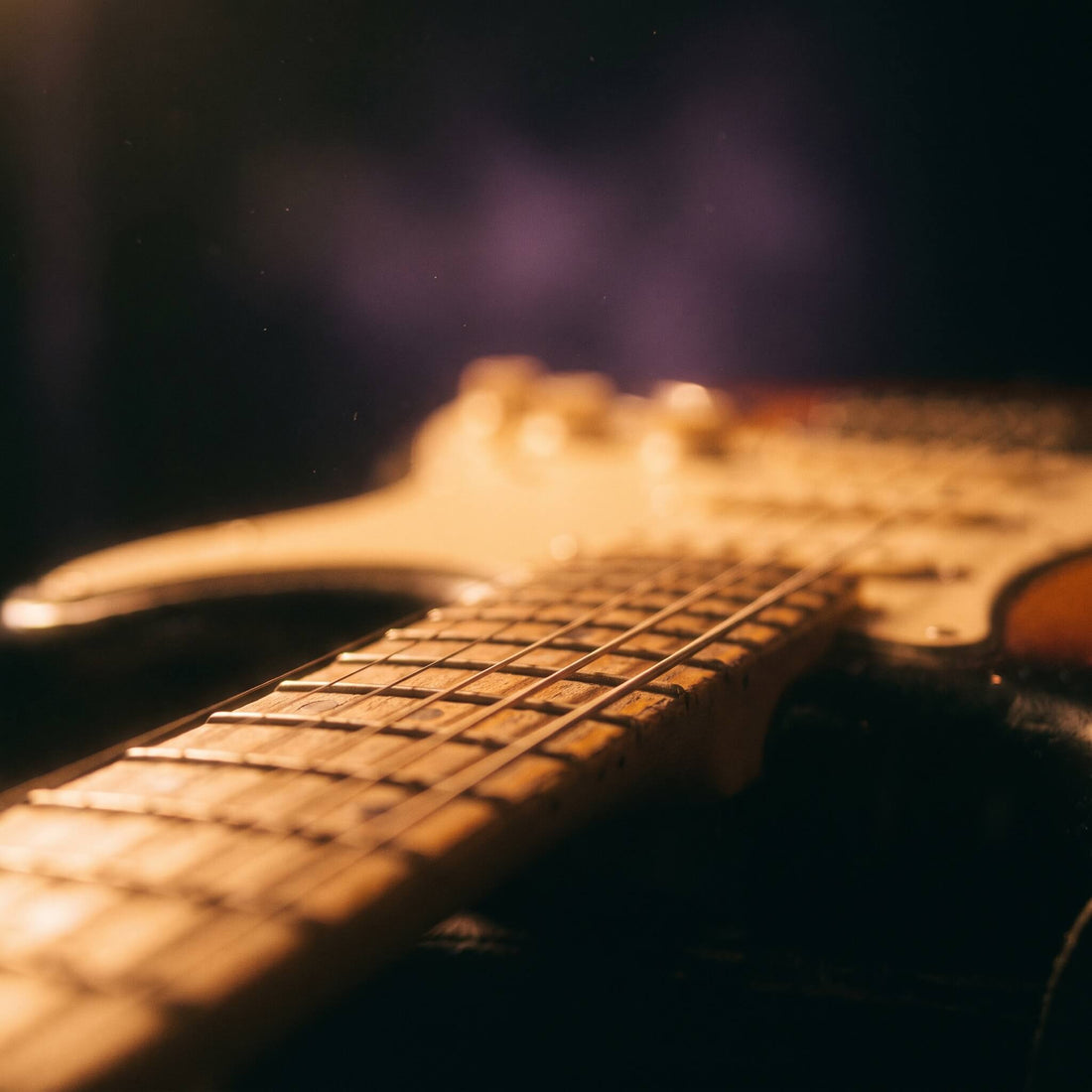 Close-up of electric guitar strings glowing in warm amber light, representing the best R&B guitar loops